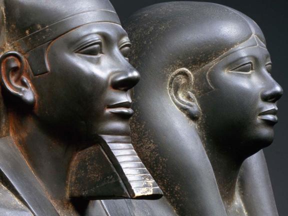 the heads of two stone Egyptian statues shown side by side