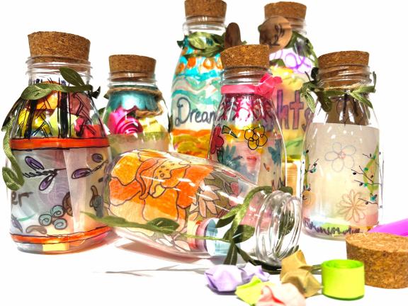 Colorfully decorated glass bottles with handmade messages and designs on them