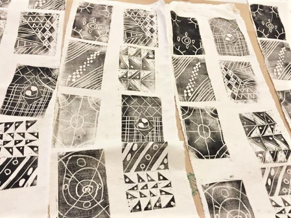 Fabric with black block printed designs by students