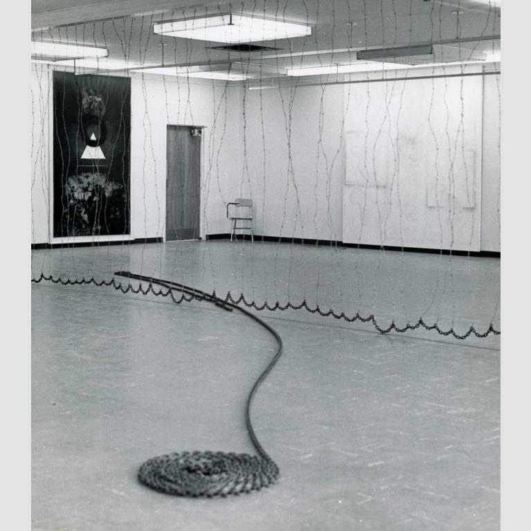 A cord travels across a floor and ends in a coiled circle.