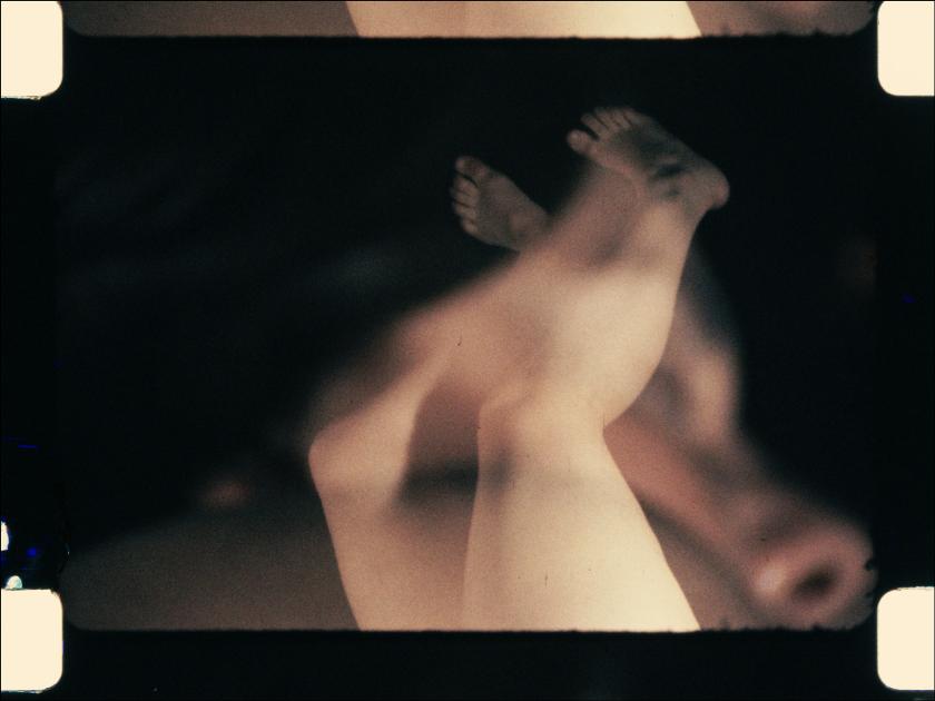 A blurred image of feet and legs against a black background.