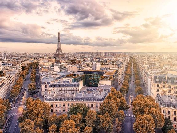 An aerial photo of Paris and the Eiffel Tower at sunset.