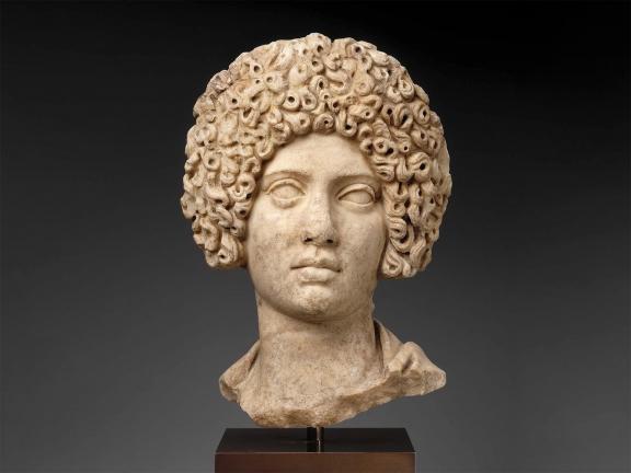 Marble bust of a woman with a full head of curly hair.