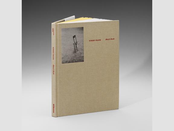 Image of book covered in a tan cloth. The title, Robert Frank: Mary's Book is in red. A small photo of a chair is in the upper left corner. 