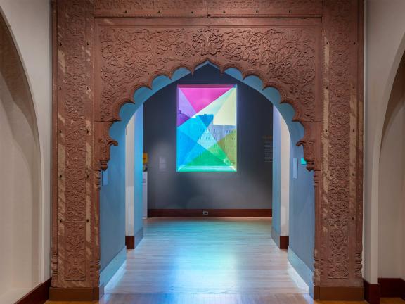 A window with various triangles of neon color overlayed across the pane.