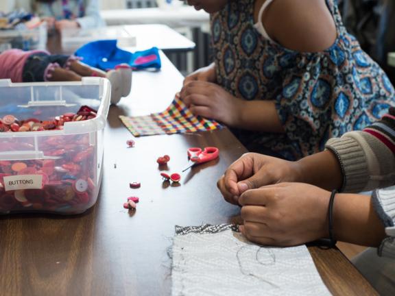 Close up of hands as girls choose buttons for sewing project