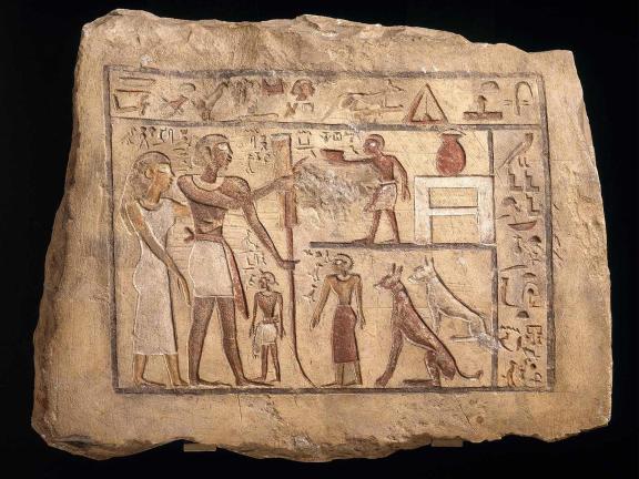 A slab of limestone etched and painted with Egyptian hieroglyphics. 
