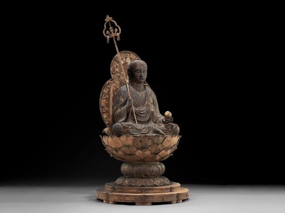 Intricately carved wood sculpture of a bodhisattva seated cross-legged base