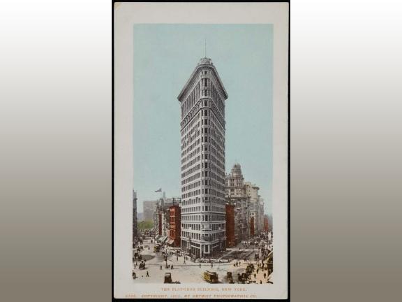 A photo of a postcard of the Flat Iron Building in New York City. 