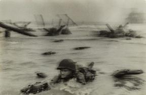 Soldiers emerge from the water during the D-Day invasions on Normandy beach.