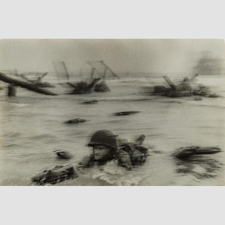 Soldiers emerge from the water during the D-Day invasions on Normandy beach.