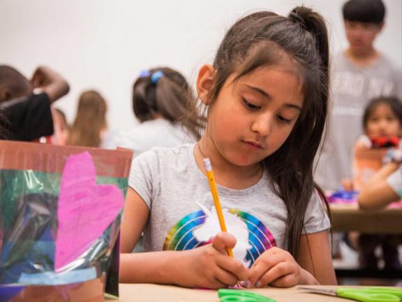 young girl drawing with a pencil