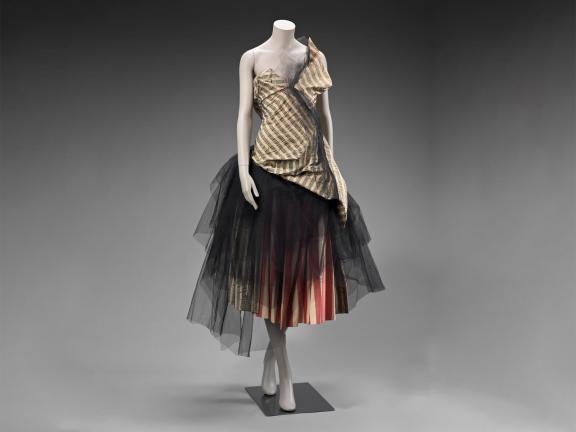 Strapless dress on a mannequin with beige top and black netting skirt