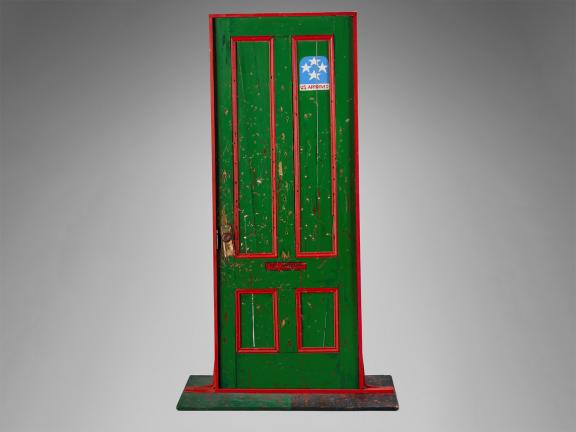 Photograph of a green door with red trim with the name Fred Hampton on it.
