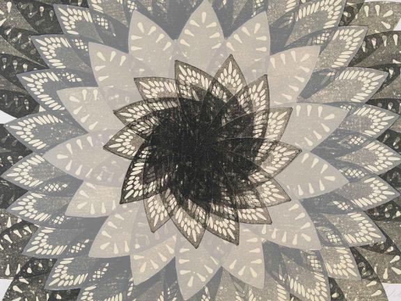 A multi-colored lithograph of iron singes repeated in the shape of a flower. 