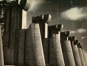 A tattered photograph of Fort Peck Dam in Montana. 
