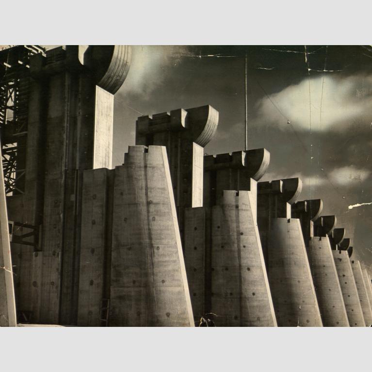 A tattered photograph of Fort Peck Dam in Montana.