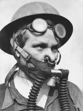 A woman, Bernice Daunora, wears a helmet, goggles on her forehead, and a breathing apparatus that covers her nose and mouth. 