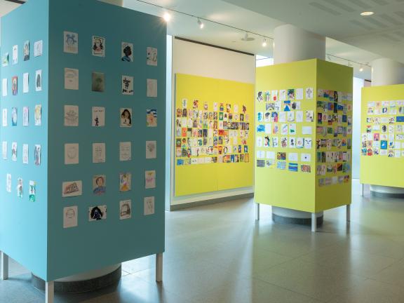 Portraits of Leadership submissions displayed on yellow and blue walls.