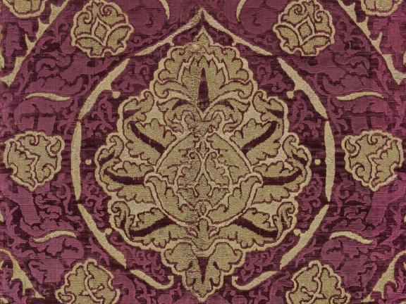 A detail of a maroon and gold silk length of velvet. 