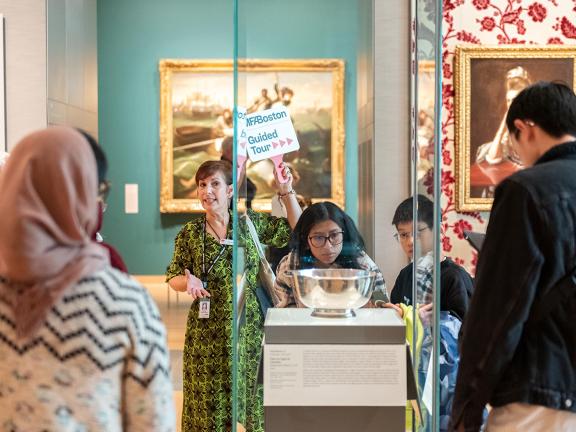A Museum tour guide speaks about the Sons of Liberty Bowl to a group of visitors 