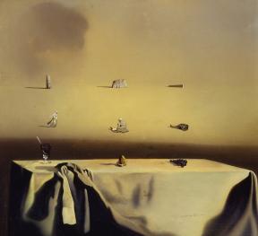 In the foreground, a group of grapes, a spoon in a glass, and a gold object sit atop a table covered in a scrunched white tablecloth; the background is dotted with small women and stone structures. 