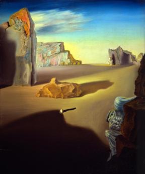 A landscape of large jagged boulders sitting in a sandy desert. 
