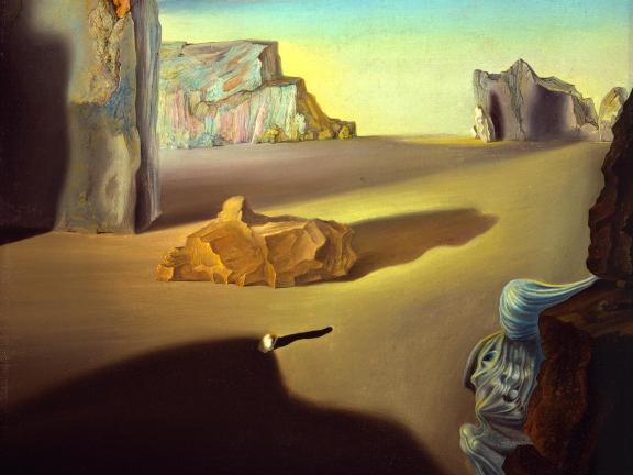 A landscape of large jagged boulders sitting in a sandy desert. 