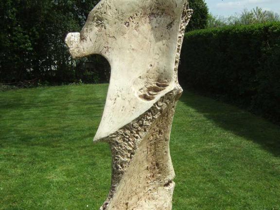 An abstract fiberglass sculpture in a green garden.