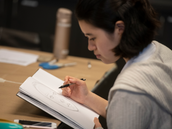 Female teen student drawing in sketchbook